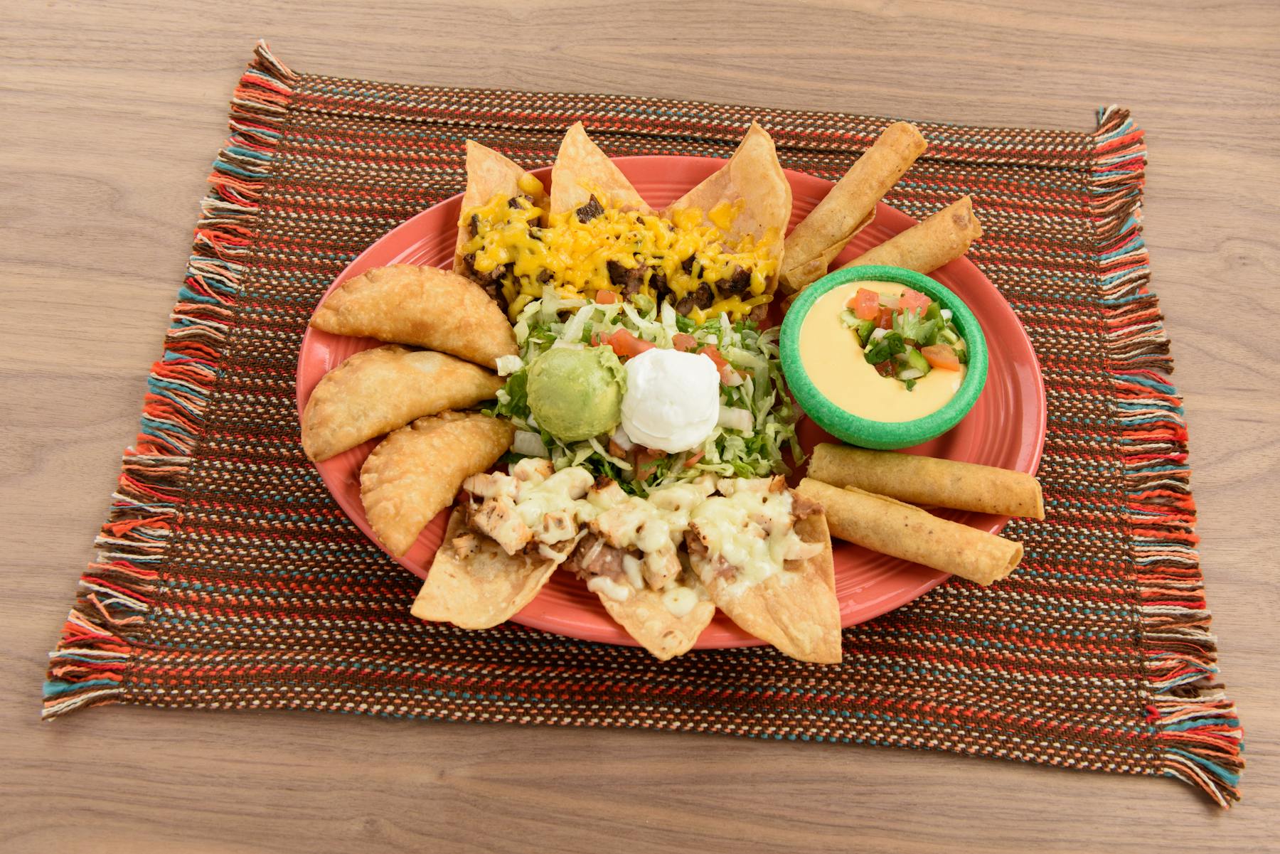 a tray topped with nachos, pastelitos, tacos and guacamole